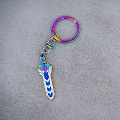 Photograph of the Terraria Zenith Keychain on a flat grey background showing off it's rainbow finish.