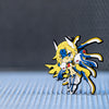 Image showcasing the Mu-12 keychain, part of the Blazblue merchandise collection, elegantly placed on a cool metallic floor, with a softly blurred metallic background.