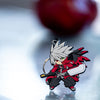 Image featuring the Ragna keychain, part of the Blazblue merchandise collection, elegantly displayed on a metal stand against a softly blurred background.