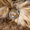 image of the Makoto pin from the BlazBlue Pin Set, placed on a bed of soft fur, highlighting its squirrel-like appearance