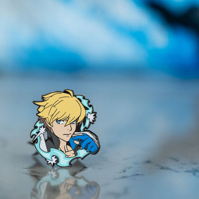 A photo of the Guilty Gear Ky Kiske pin, it is standing on a marble floor with blue swirling hues in the background. The blue hues are reflecting off the white and black marble giving it a surreal effect.