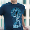 Image is a close up photo of a man wearing the Mega Man Gear Up shirt. He is leaning against a parking lot balcony with buildings in the background that are nicely blurred.