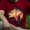 This image is a closeup of the Monster Hunter Expedition shirt. The man wearing it is kneeling down, and is slightly out of focus, while the design is nice and crisp.
