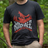 This image is a close up of the Rotten Vale Monster Hunter shirt. A man is wearing it with his hands in his pockets in the middle of the forest, with a nice green blurred background.