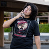 Photo of a man wearing the Welcome to the Metaverse Persona 5 tee. He is making an expression similar to Joker in the game.