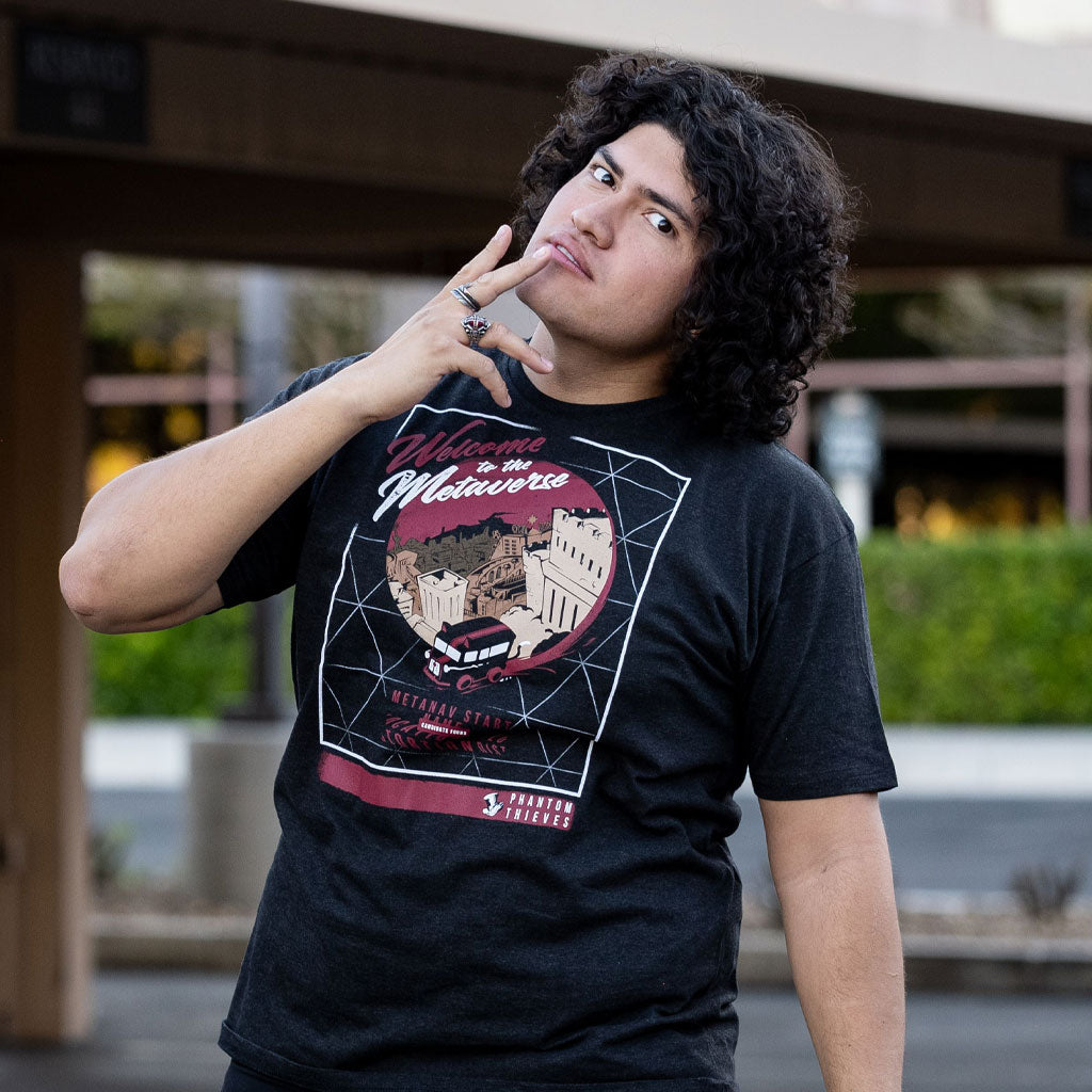 Photo of a man wearing the Welcome to the Metaverse Persona 5 tee. He is making an expression similar to Joker in the game.