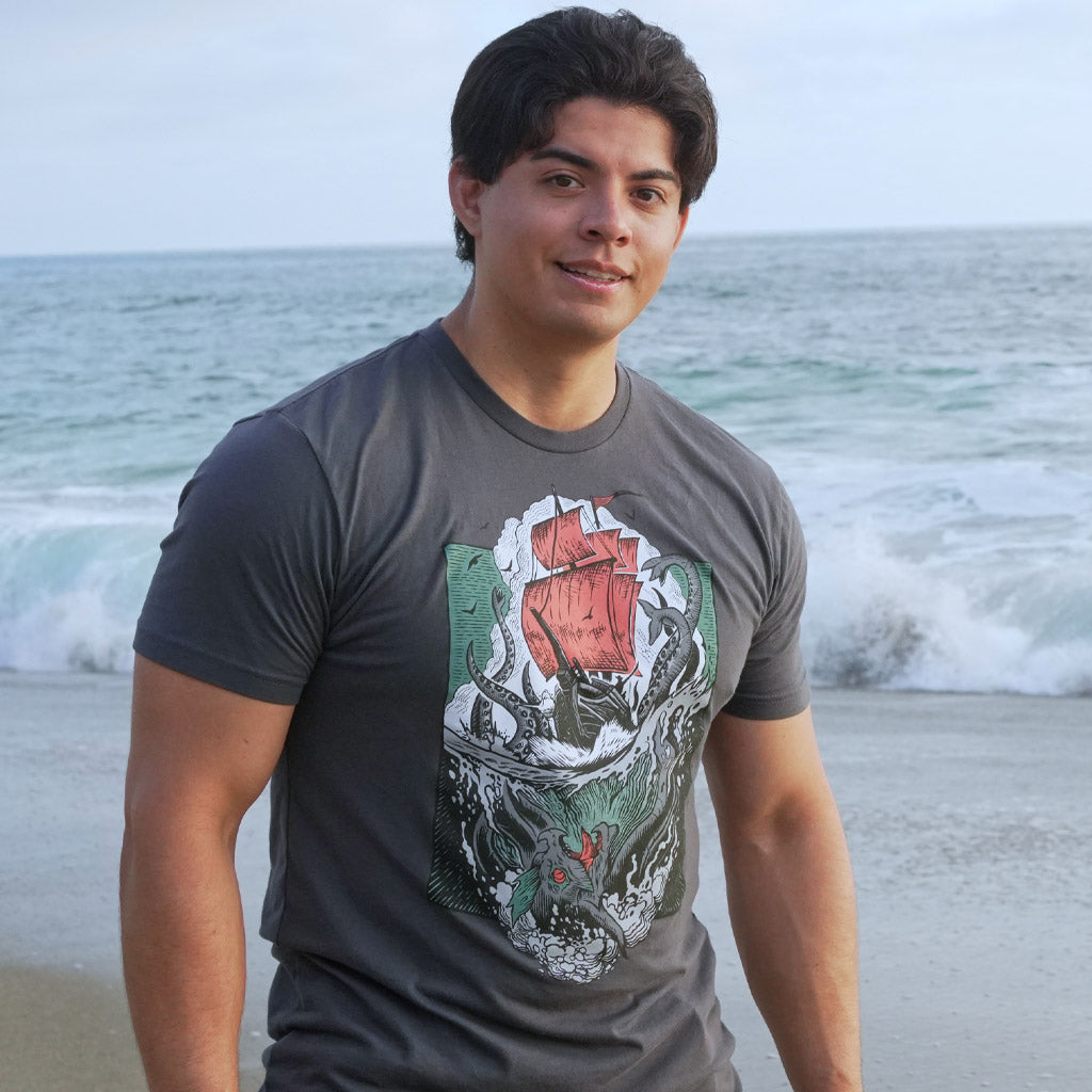 Man at the beach wearing the Sea of Thieves Kraken T-Shirt inspired by the legendary sea monster