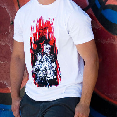 A Close up photo of a man wearing the Street Fighter Ansatsuken shirt. He is leaning on a wall that is adorned with graffiti.