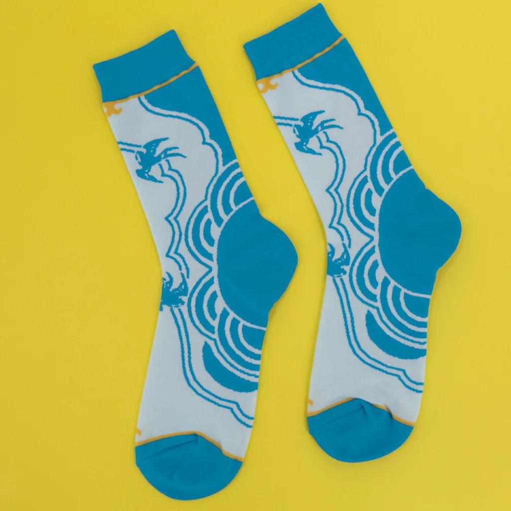 Chun-Li Street Fighter 6 socks flat lay on yellow background, blue and white design
