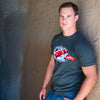 A photo of a man wearing the Street Fighter Respect tee. He is leaning on the wall at the end of a tunnel.