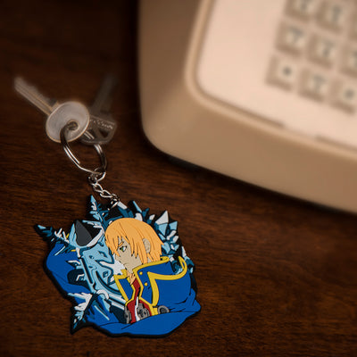 Image displaying the Jin keychain, adorned with keys, placed on a desk near a telephone. This keychain is part of Blazblue merchandise.