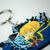 Blazblue Jin Portrait keychain by Eighty Sixed. Showing the keychain cutout on a pixelated background.