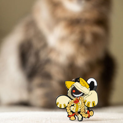 Image showcasing the Taokaka keychain, a piece of Blazblue merchandise, with a background featuring a furry, creamy cat.